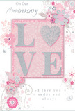 This anniversary card presents a tender scene of enduring romance, its palette of pastel pinks, creamy whites, and soft silvery greys echoing the tones of a classic love bouquet. At the centre, the word LOVE stands proudly in raised, glitter-soft lettering, with the O transformed into a shimmering, textured heart picked out in silver, like a charm you might find tucked into a bouquet delivered in Orpington. The embossed details offer a pleasing tactile contrast against the smooth card, encouraging a gentle touch. Around this central word, a halo of delicate floral illustrations unfolds: blossoms in blush and mauve seem to unfurl in soft, watercolor-like strokes, their fine outlines and shaded centres suggesting both artistry and care. Slender vines, swirling stems, and wisps of foliage curl through the design, adding rhythm and a sense of movement, much like the natural flow of greenery in a hand-crafted anniversary arrangement. Scattered among the flowers are tiny flourishes-petals in motion, graceful curls, and subtle butterfly silhouettes-that bring a hint of whimsy and an almost storybook charm, as though capturing a spring garden just off Orpington High Street in full, gentle bloom. The phrases On Our Anniversary and I love you today and always appear in elegant, understated script, the lettering fine and slightly flowing, giving the impression of a heartfelt handwritten note. Overall, the card conveys a feeling of quiet intimacy and meaningful celebration, ideal for marking a shared journey that has grown season by season, like a favourite garden nurtured over many years in Orpington.